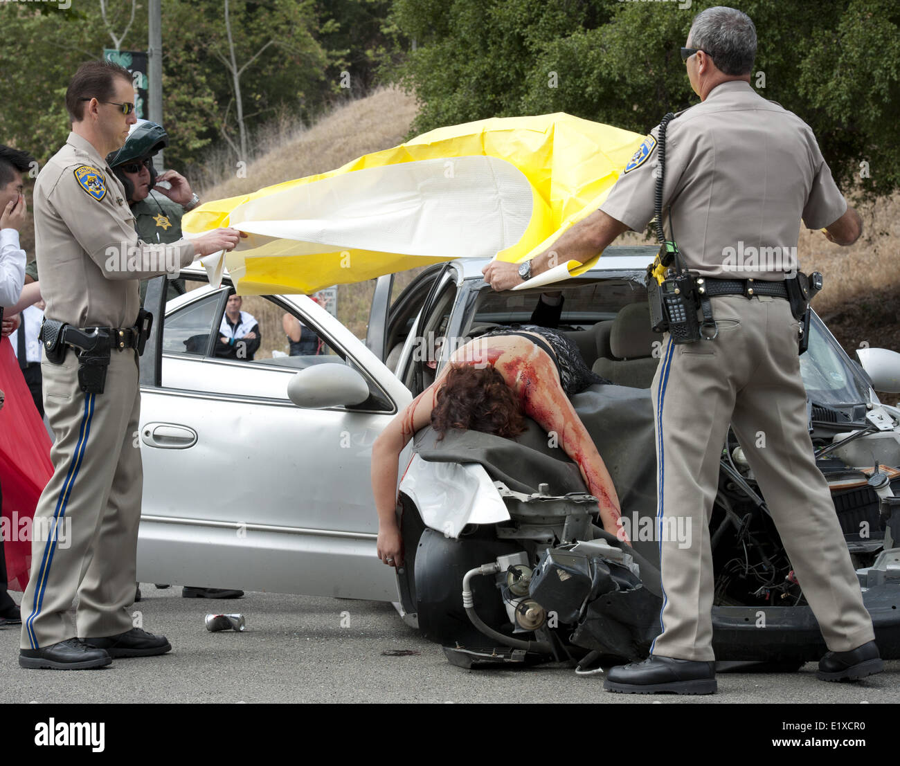 Aliso Niguel, USA. 24th May, 2013. California Highway Patrol officers place a body blanket over an Aliso Viejo High School student volunteer playing the part of a passenger fatality victim, killed in a car driven by a drunk driver. Aliso Niguel High School Students in Orange County, California, were presented with a simulated DUI fatality accident scene on Friday morning. The Orange County Fire Authority, Orange County Sheriff's Department, California Highway Patrol, Mission Hospital, Doctor's Ambulance Service and O'Connor Mortuary along with Aliso Viejo and Laguna Niguel citizen v Stock Photo