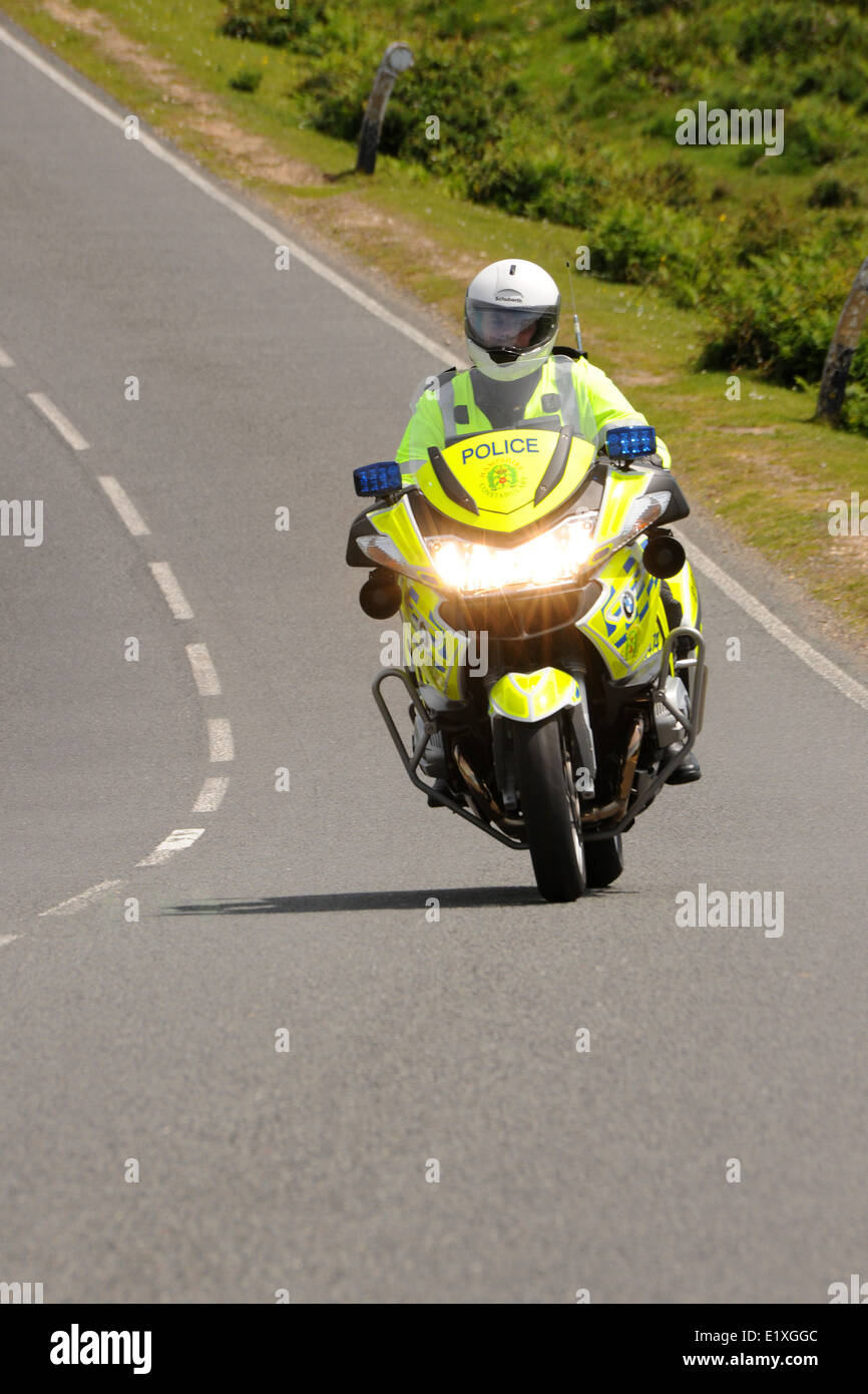 A police motorcyclist on a BMW R1200RT motorcycle against  able sky and clouds. England. June 2014. Stock Photo