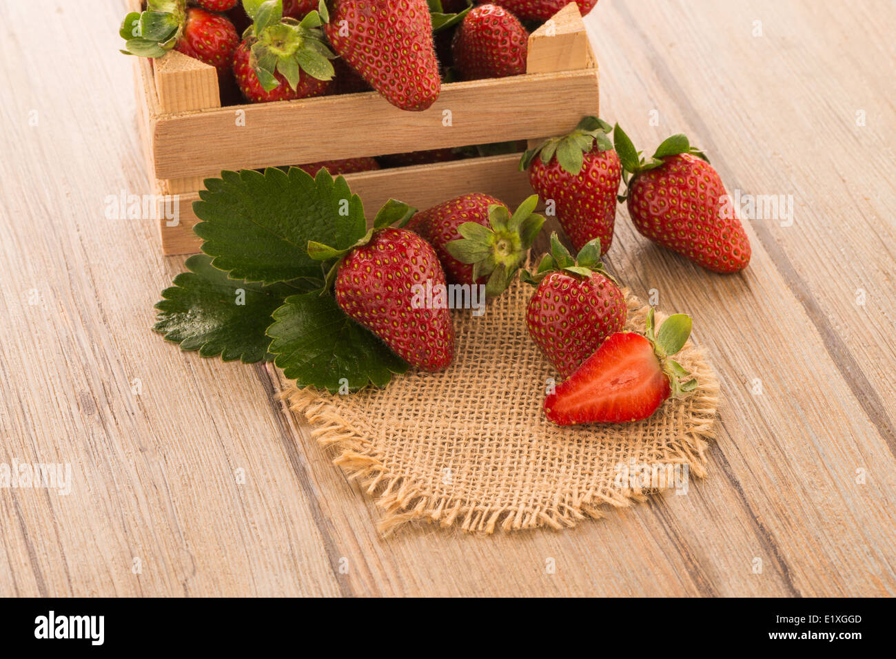 Strawberries over odl brown wooden table background Stock Photo - Alamy