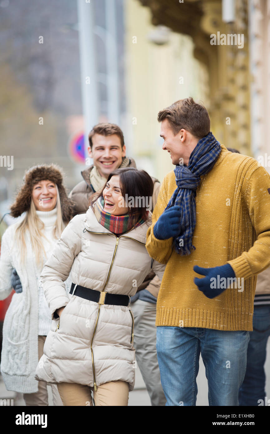 Cheerful young couples in warm clothing on city street Stock Photo