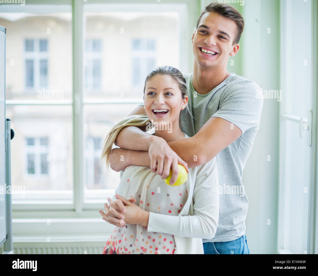 Happy loving couple looking away in house Stock Photo