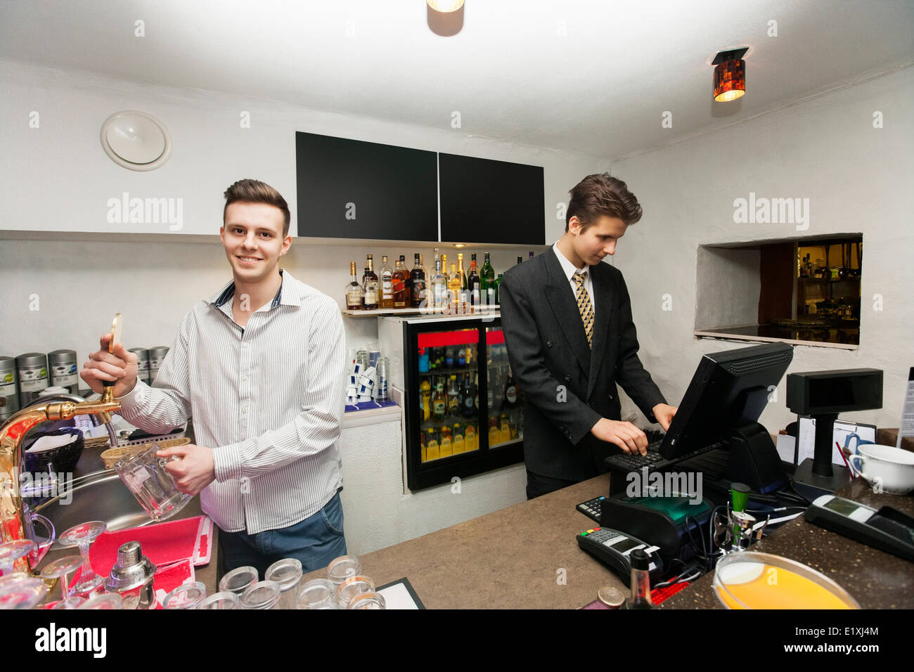Portrait of bartender with cashier at counter in restaurant Stock Photo