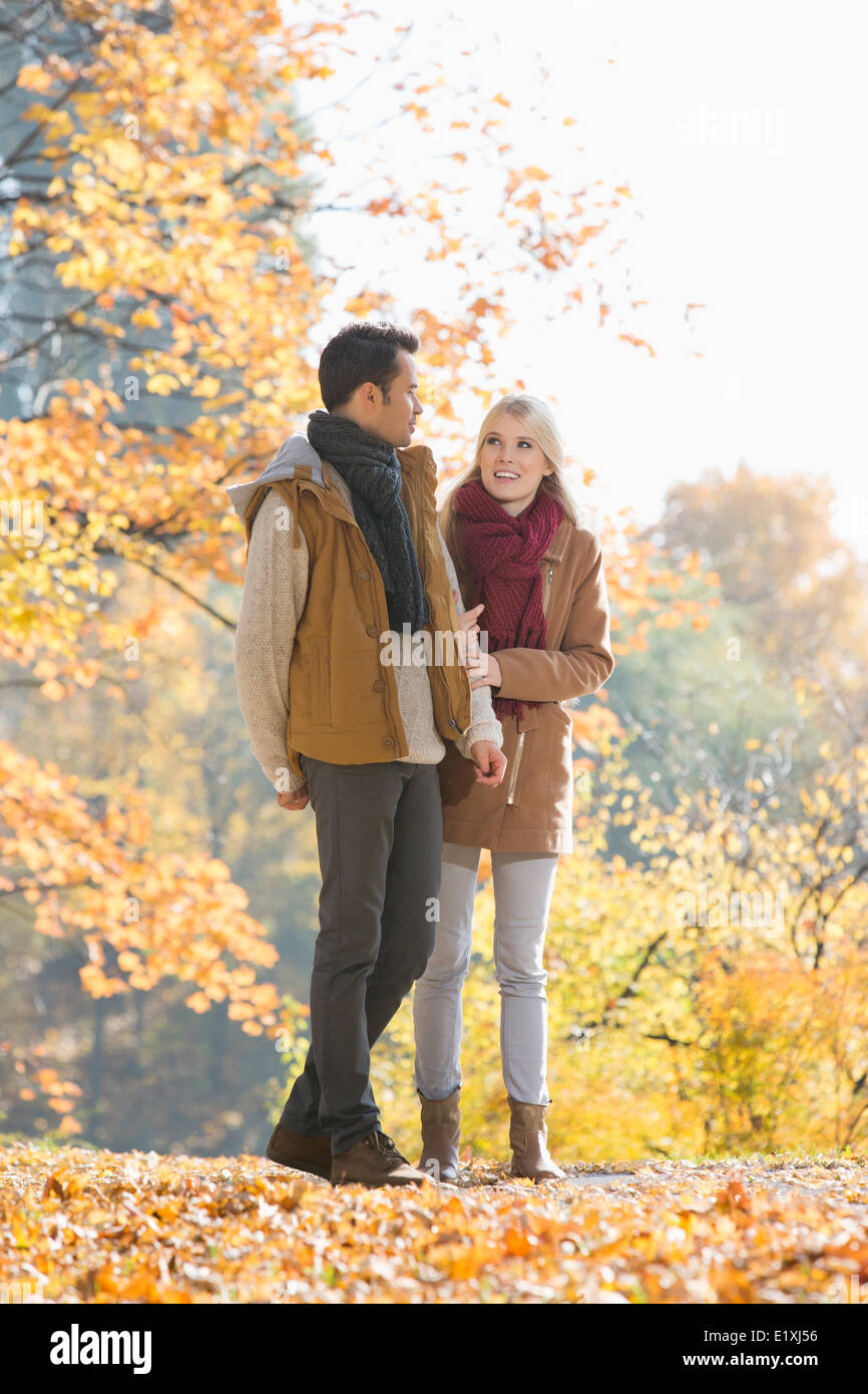 Full length of couple walking in park during autumn Stock Photo - Alamy