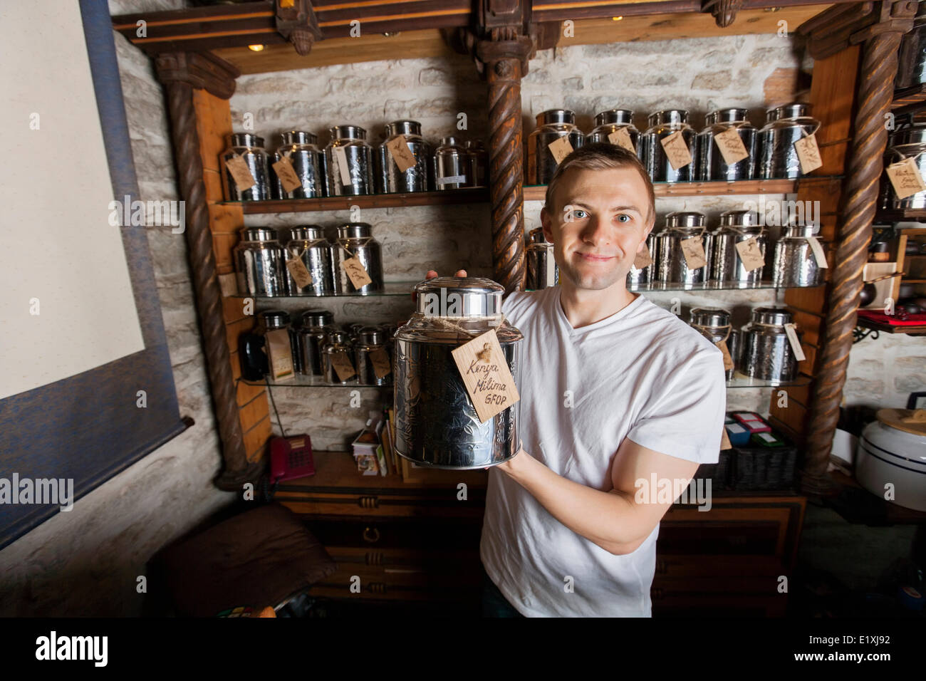 Portrait of smiling male owner displaying tea container in store Stock ...