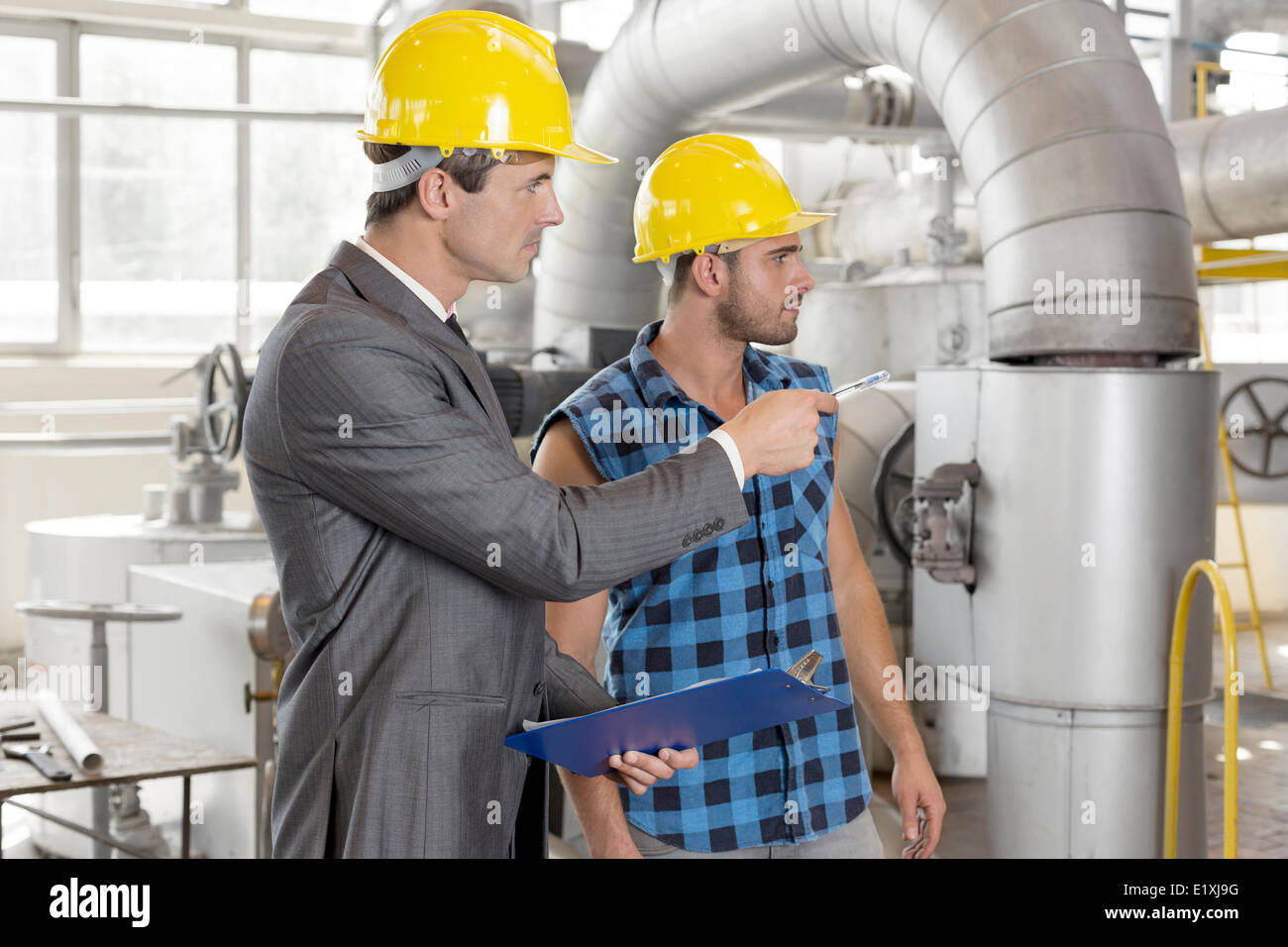 Worker with supervisor inspecting industrial area Stock Photo - Alamy