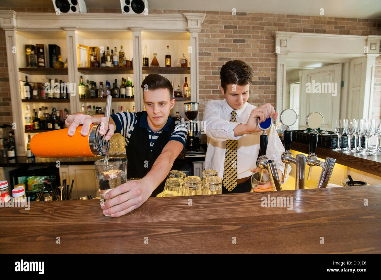 Bartenders working at counter in restaurant Stock Photo Alamy