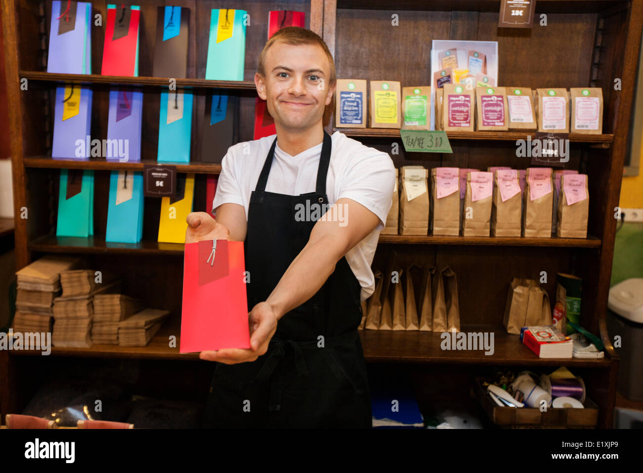 Portrait of male salesperson showing product in coffee store Stock Photo