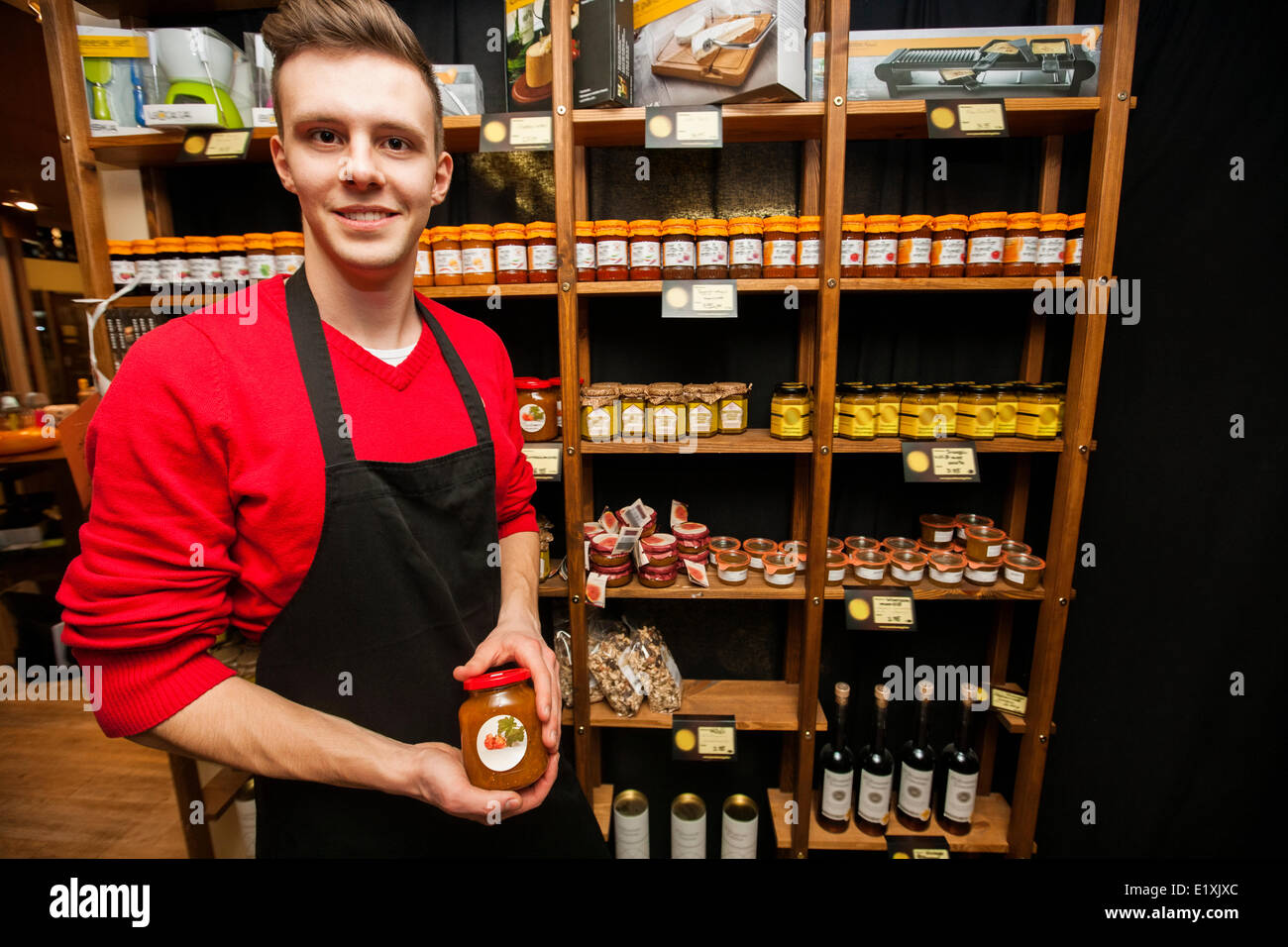 Portrait of smiling salesperson holding jar in supermarket Stock Photo