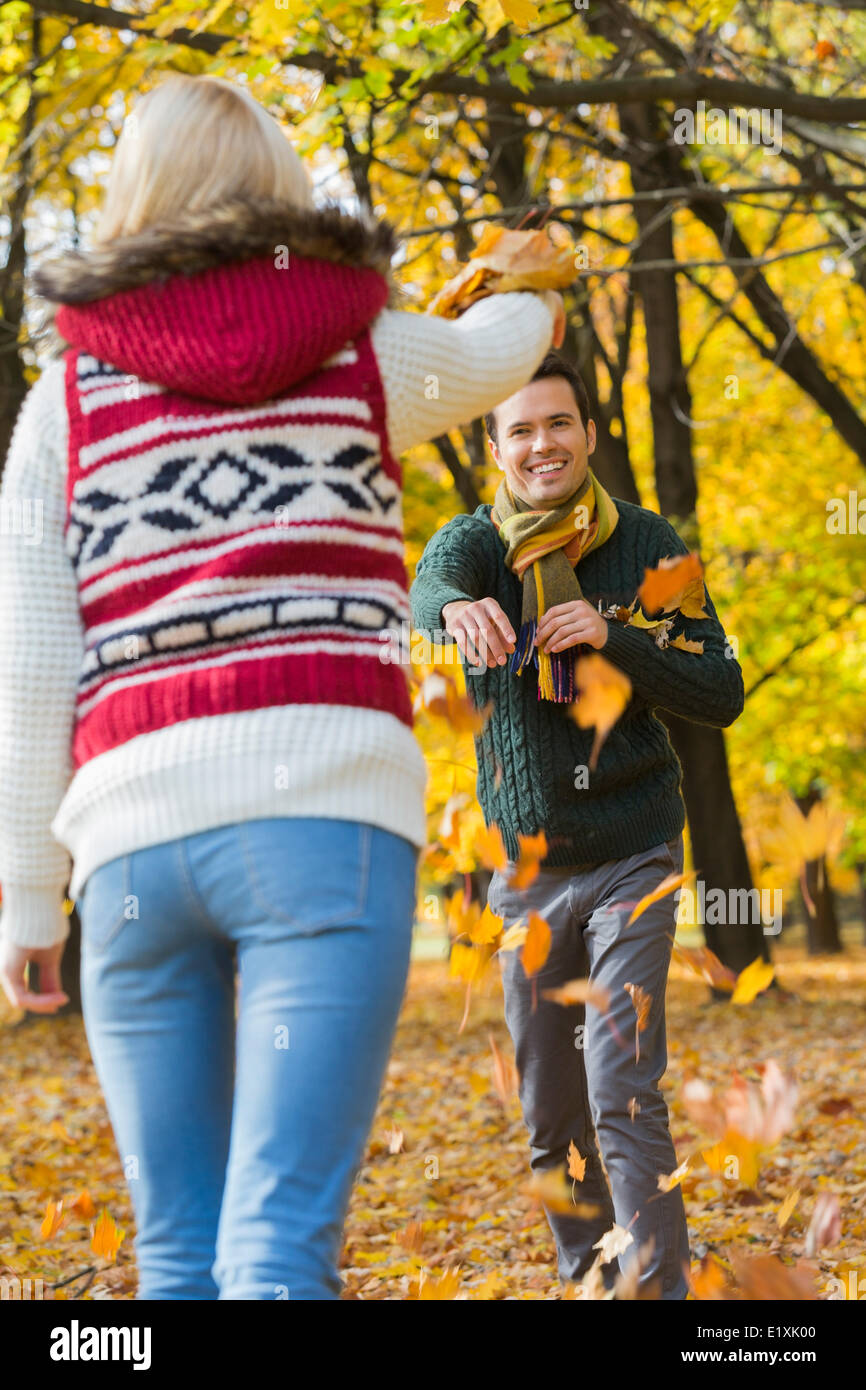 Happy young couple playing with autumn leaves in park Stock Photo - Alamy