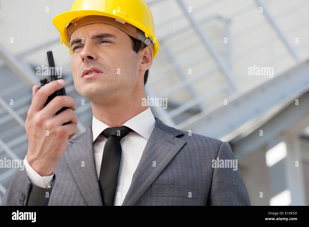 Young male architect talking on two-way radio outdoors Stock Photo