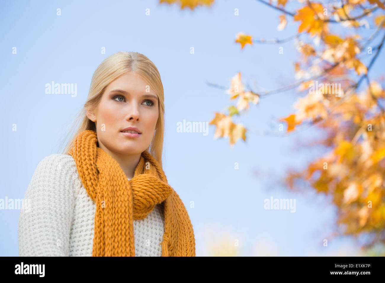 Low angle view of thoughtful young woman against sky Stock Photo