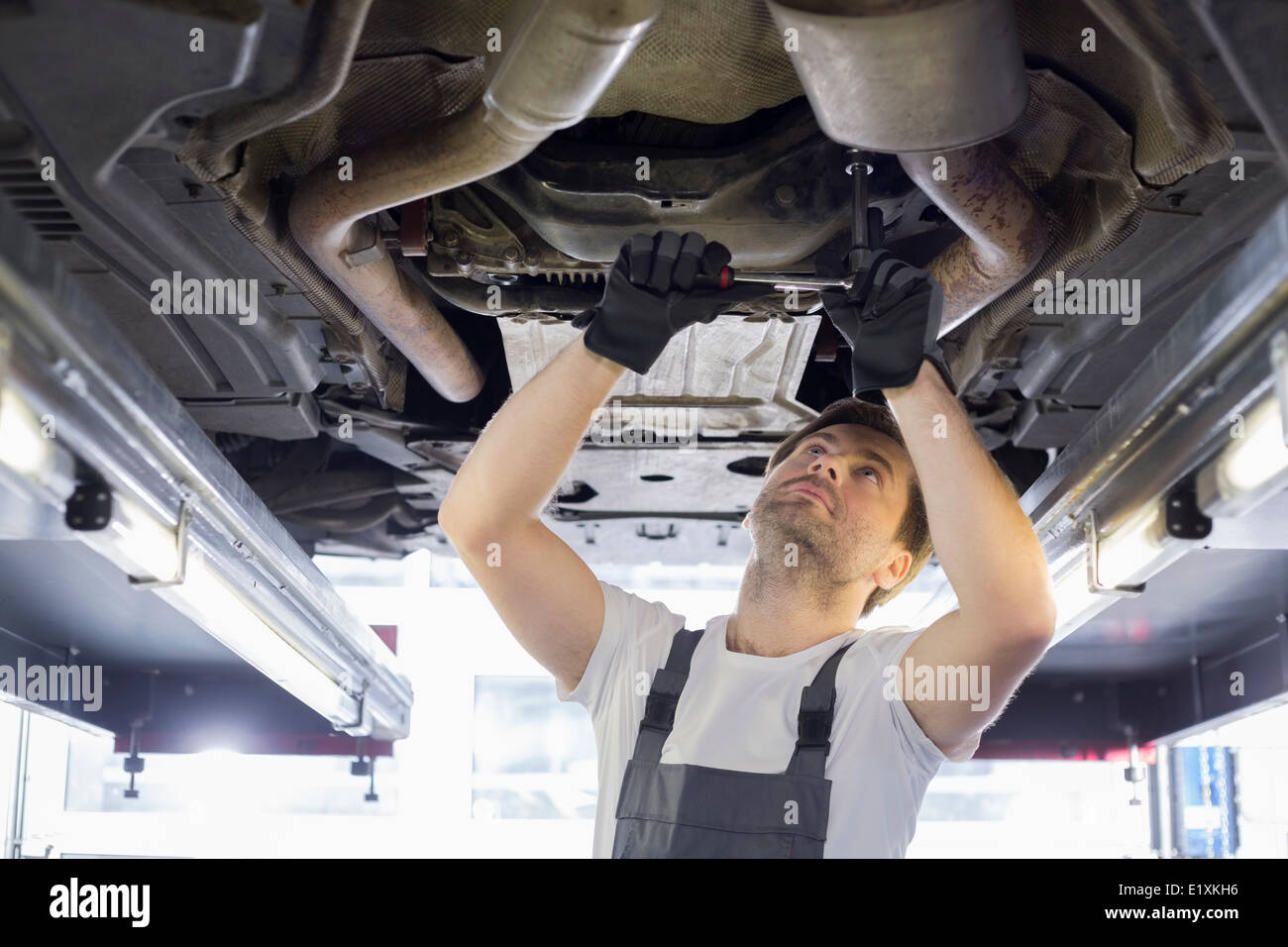Mid adult automobile mechanic repairing car in workshop Stock Photo