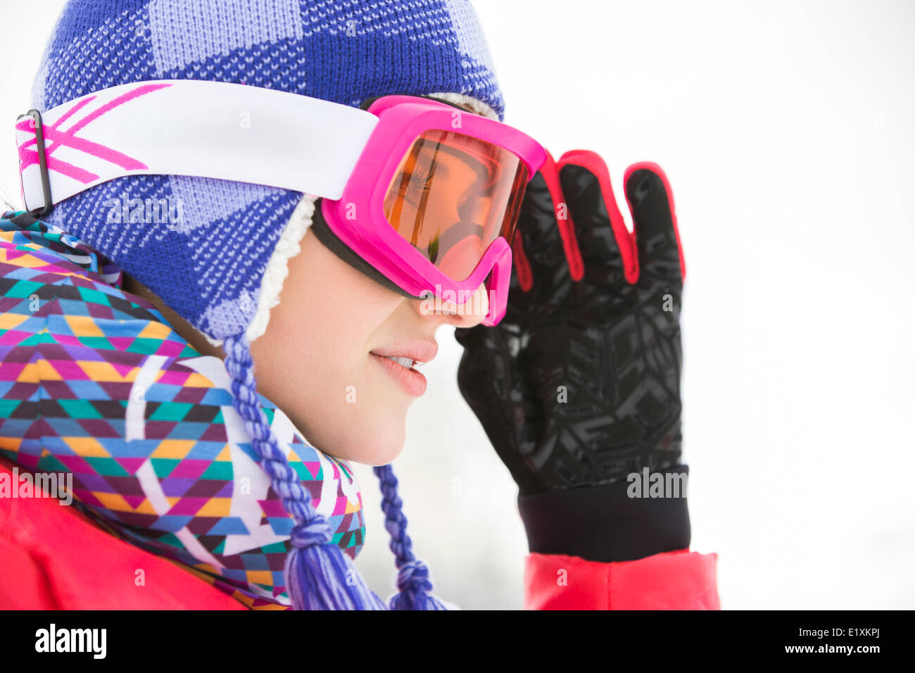 Side view close-up of beautiful young woman in ski goggles looking away Stock Photo