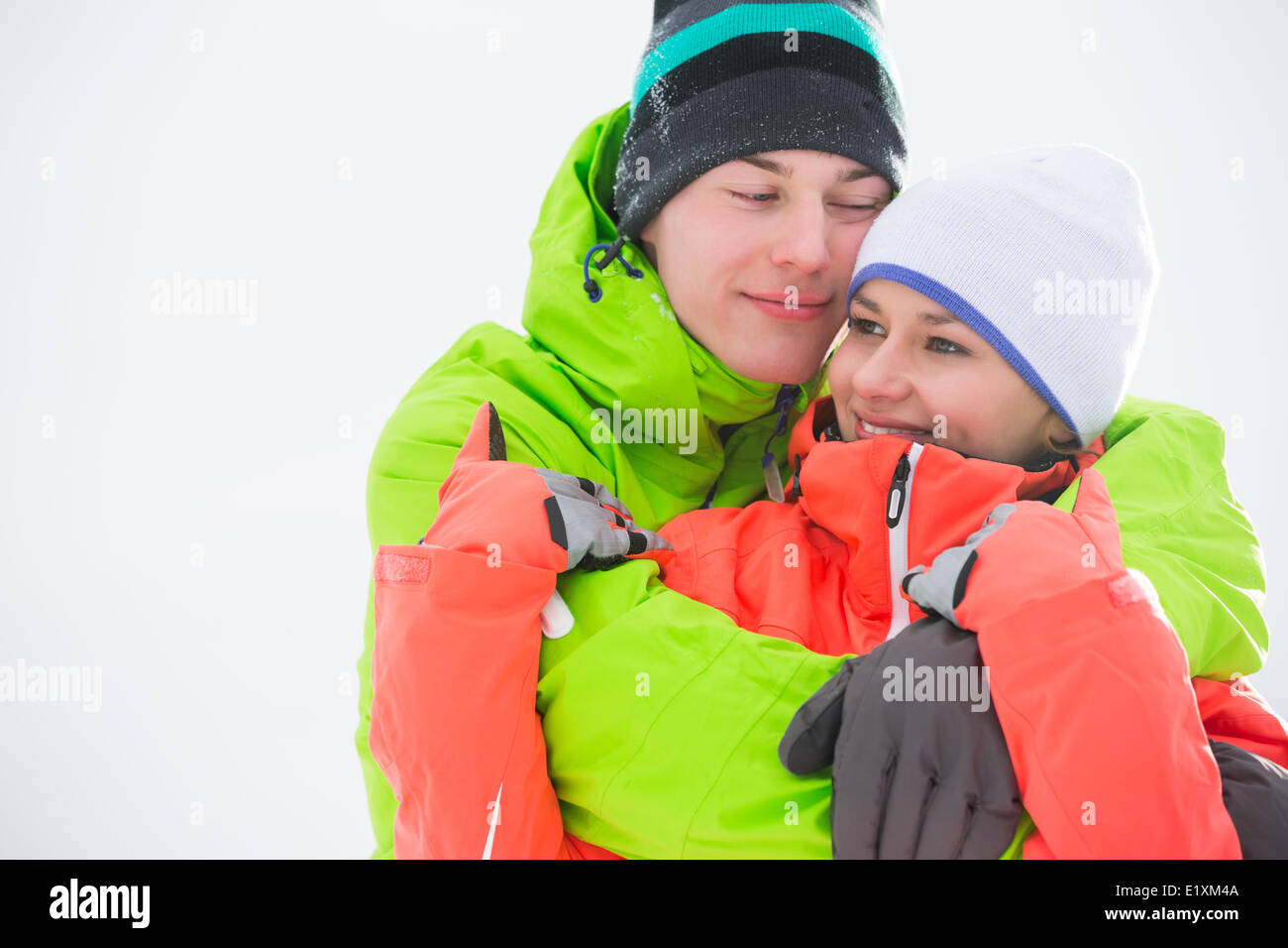 Loving young couple in warm clothing embracing outdoors Stock Photo