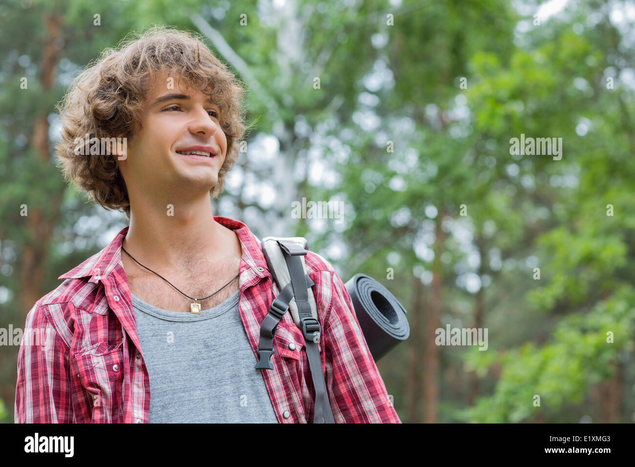 Smiling male hiker looking away in forest Stock Photo