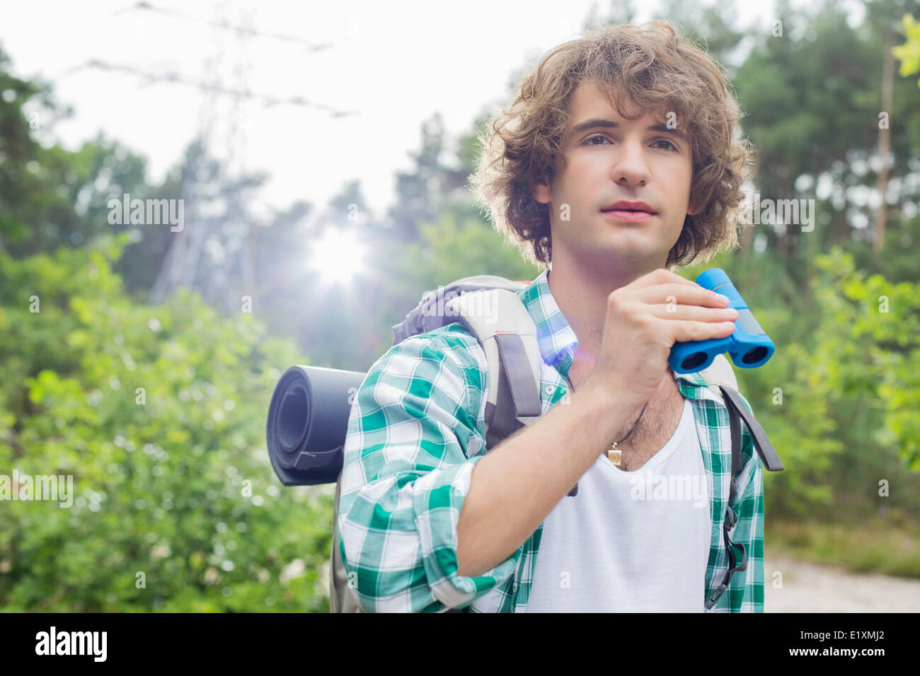 Young male hiker with binoculars in forest Stock Photo