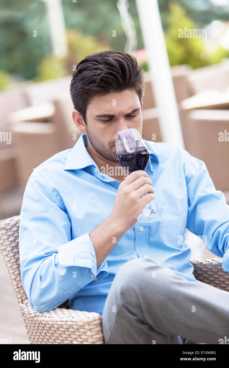 Young man drinking red wine at outdoor restaurant Stock Photo - Alamy