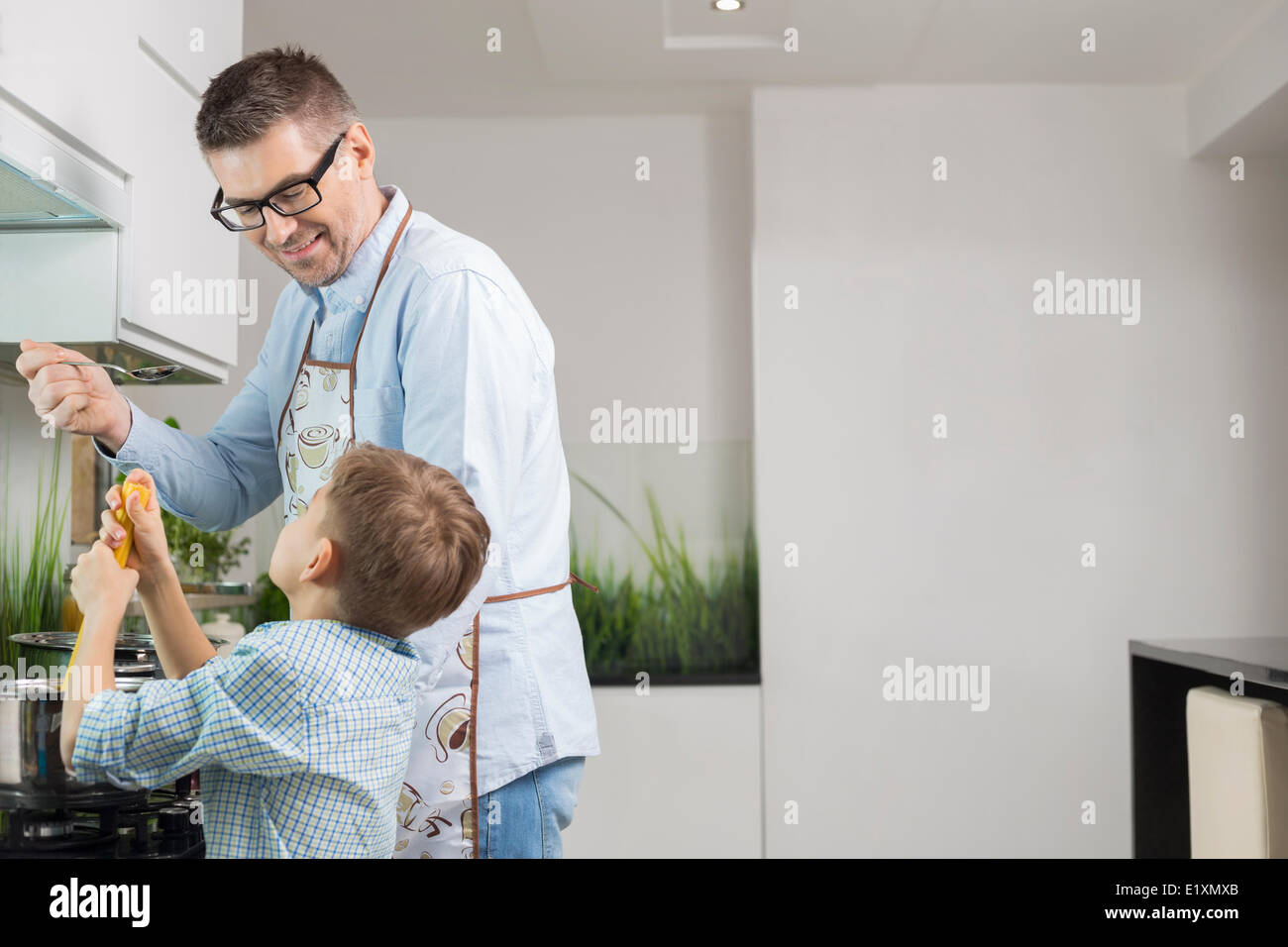 Happy father and son preparing spaghetti in kitchen Stock Photo - Alamy