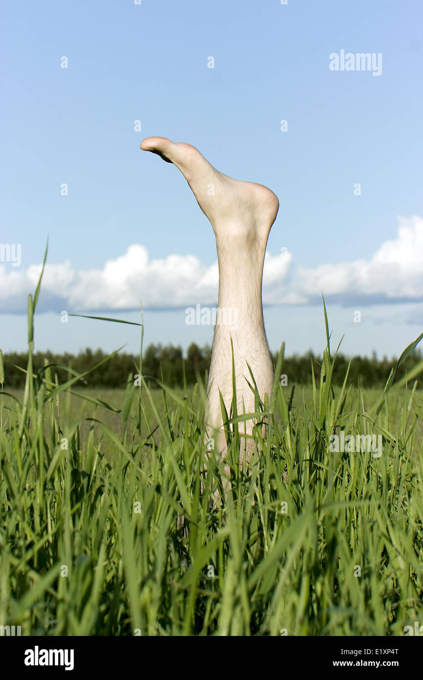 Foot sticking out of a grass Stock Photo Alamy