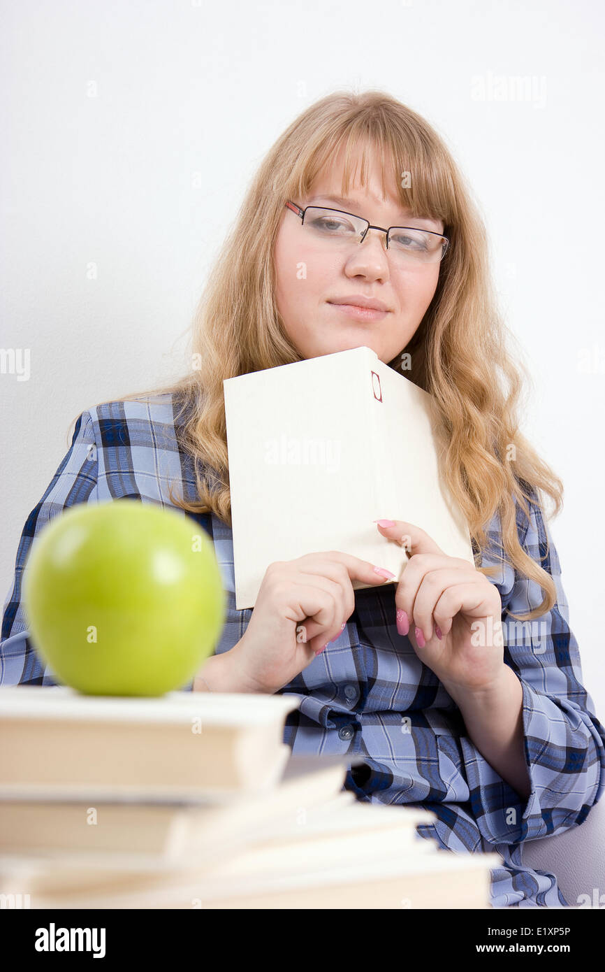 The girl with the book looks at an apple Stock Photo - Alamy