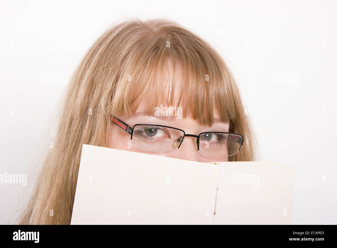 The girl hides behind the book Stock Photo