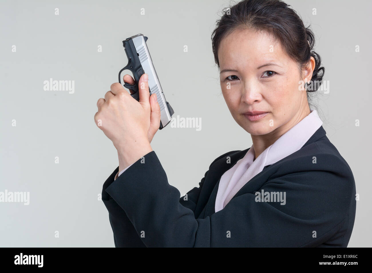 Woman holding a hand gun Stock Photo