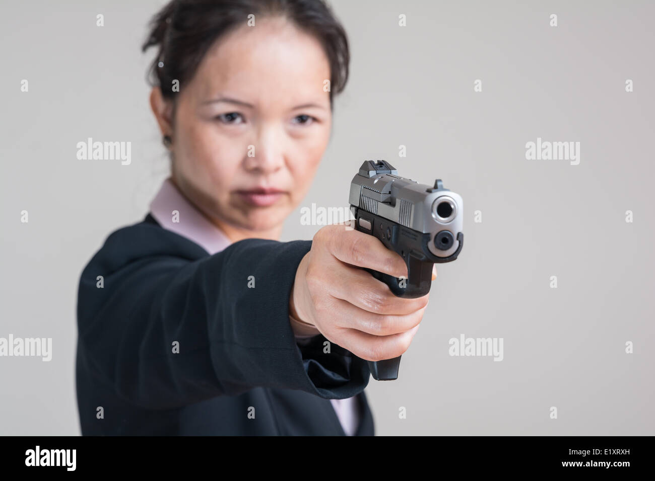 Woman aiming a hand gun Stock Photo
