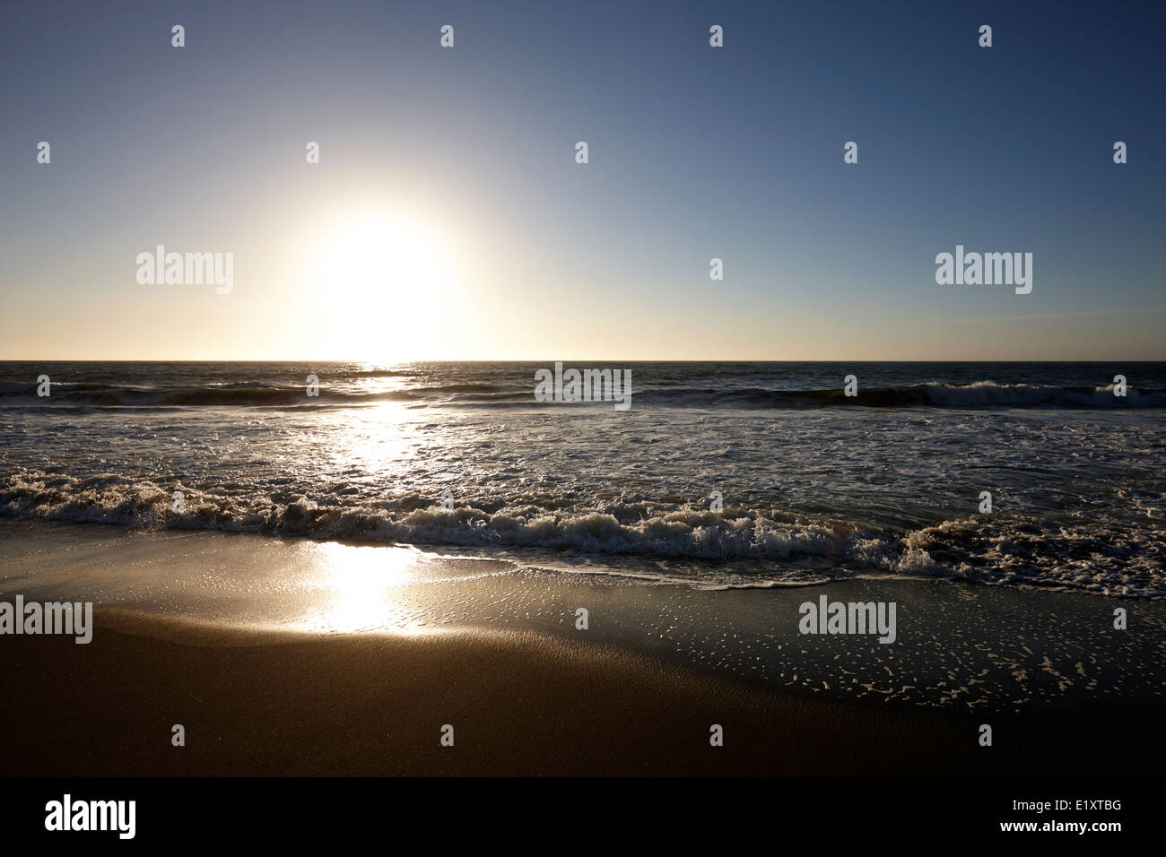 sun setting over sandy beach on the pacific ocean los pellines chile Stock Photo