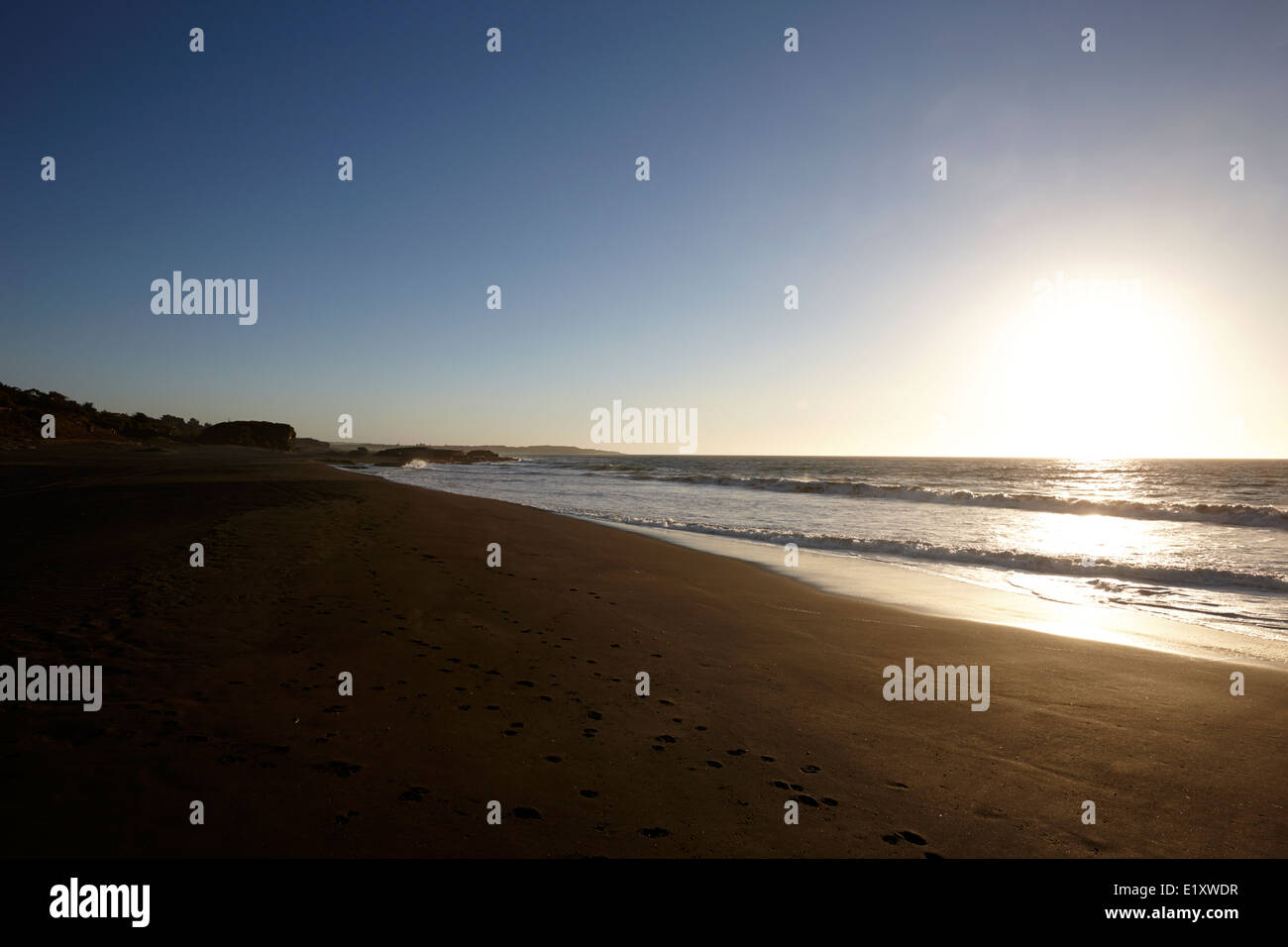 sun setting over sandy beach on the pacific ocean los pellines chile Stock Photo