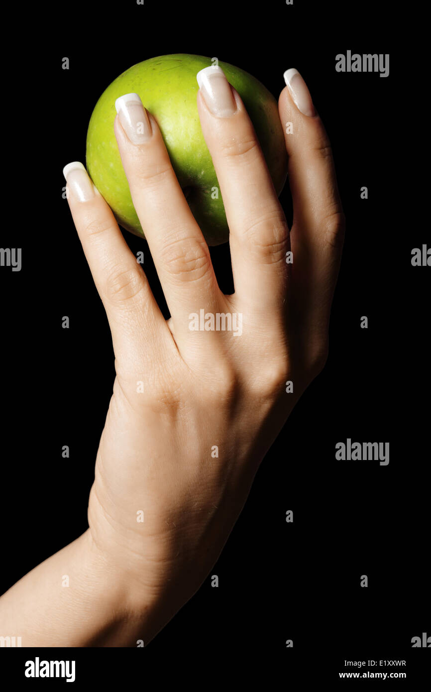Green apple in manicured hand Stock Photo