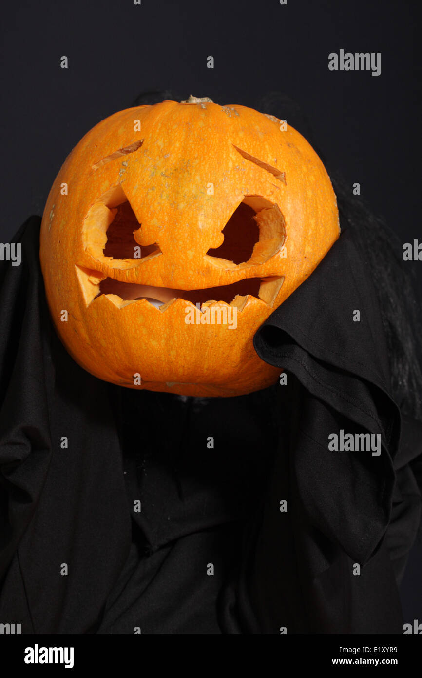 Halloween pumpkin in black robe Stock Photo