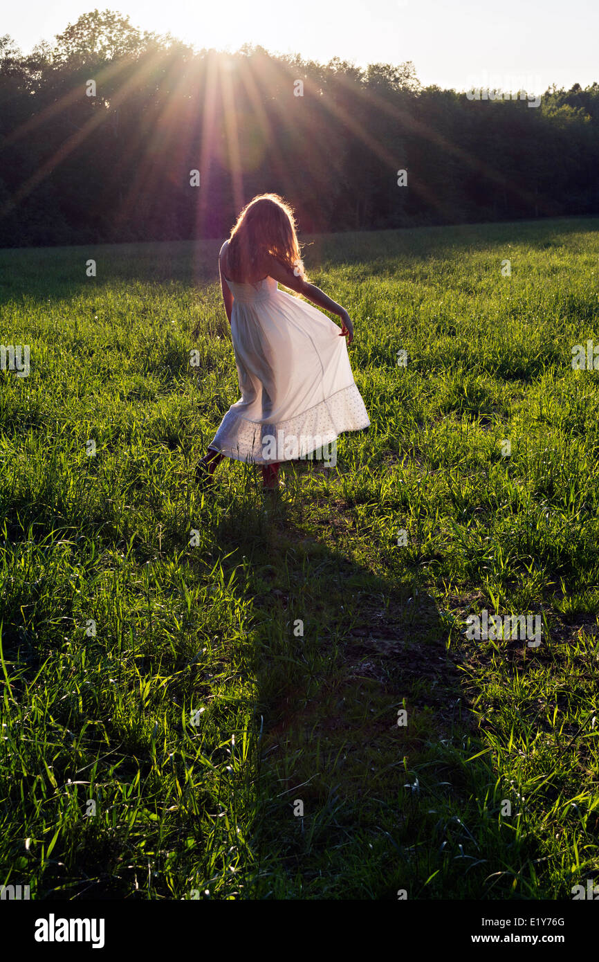 Emily Brown dancing in a field as the sun sets. Stock Photo