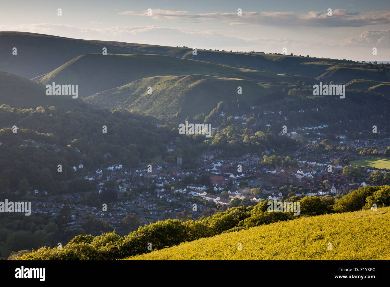 Evening sunshine filters through the Long Mynd onto Church Stretton nestling in the valley, Shropshire - as seen from Ragleth Hi Stock Photo