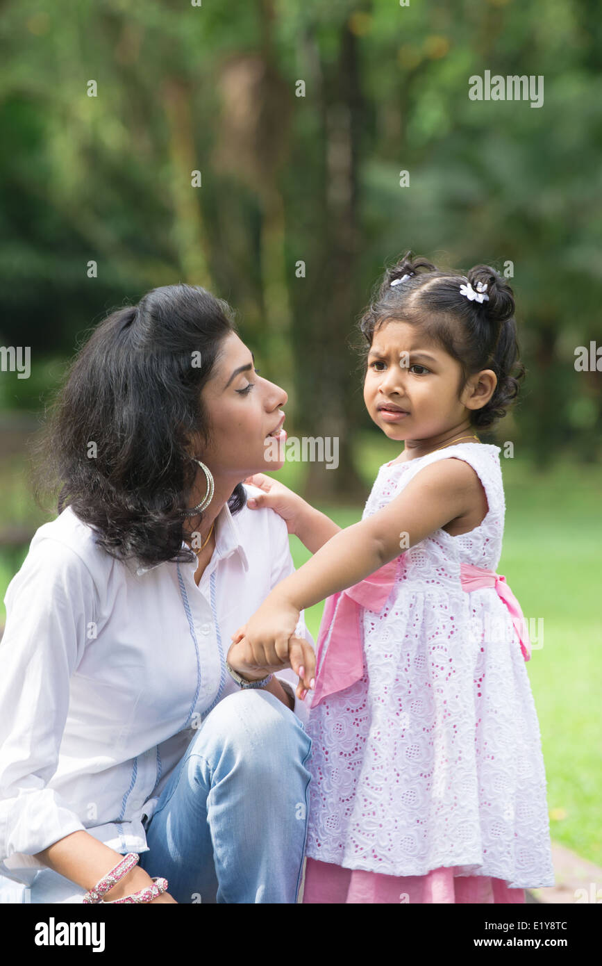 indian mother conforting her daughter in outdoor park Stock Photo