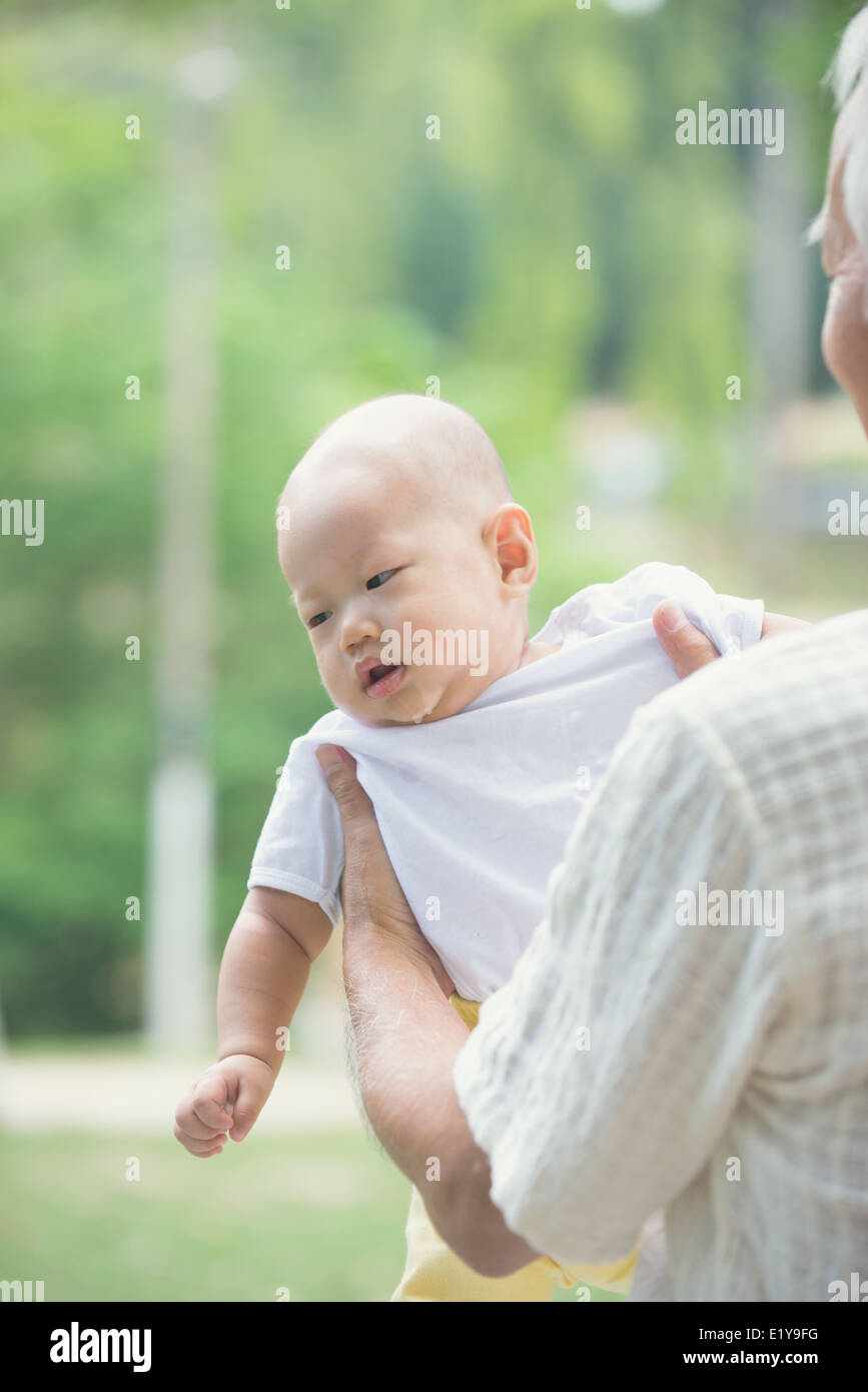 chinese asian grandfather having fun with his grandson outdoor Stock
