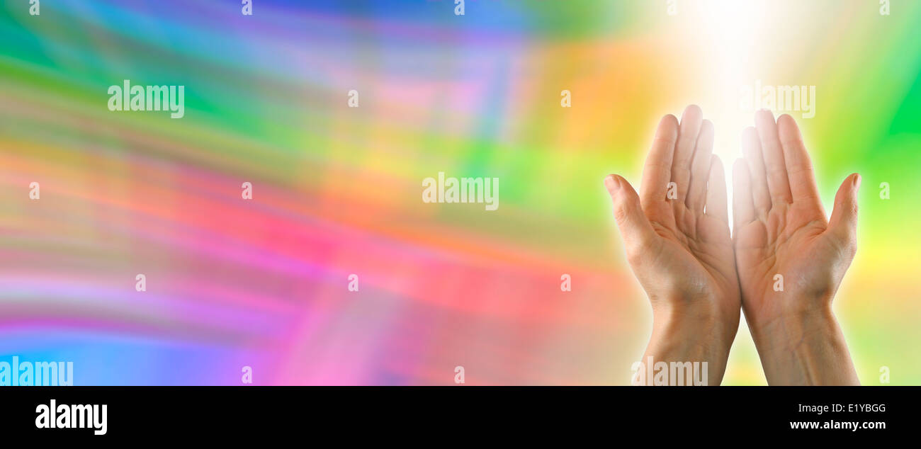 Color healing website banner with healer's hand outstretched palm up and a shaft of white energy Stock Photo