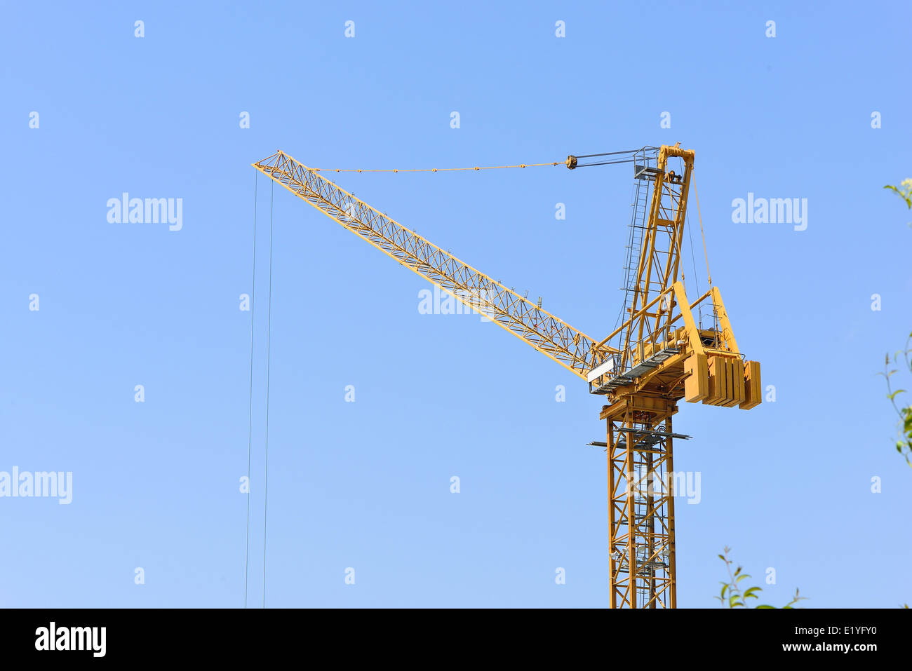 yellow tower crane at construction site in sunny day Stock Photo