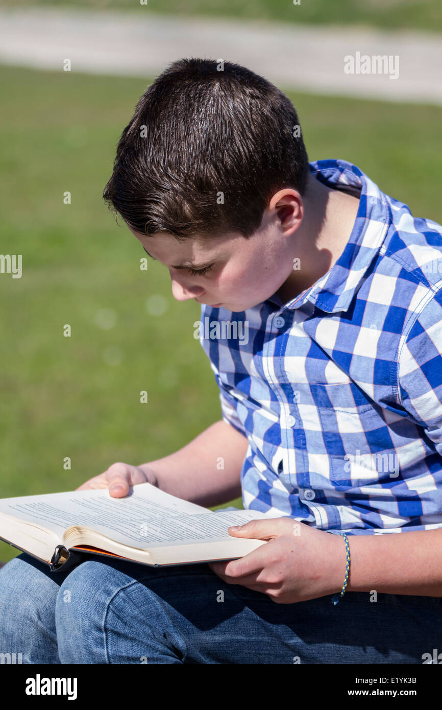Shallow Reading Childhood.Young boy reading a book in the woods with shallow depth of ...