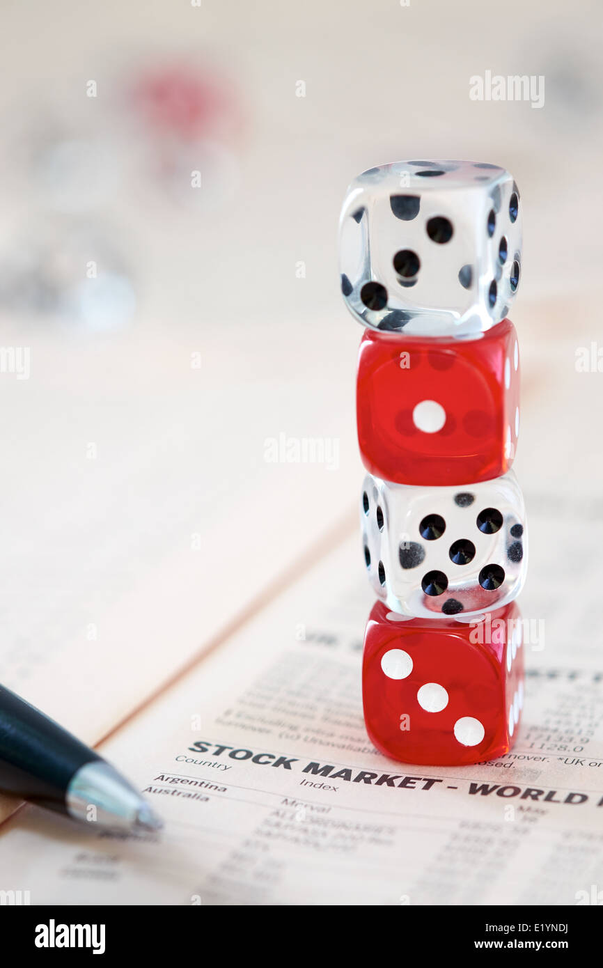Odds Stacked against you. Coloured dice on top of the financial section of a newspaper. Stock Photo
