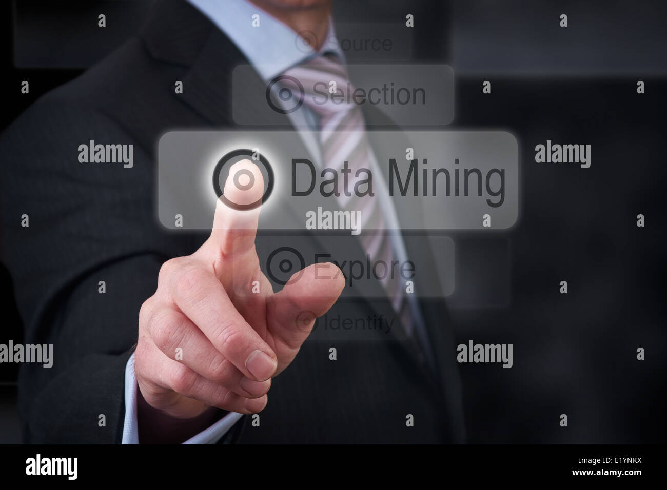 A businessman Pointing to a data mining button on a clear screen. Stock Photo