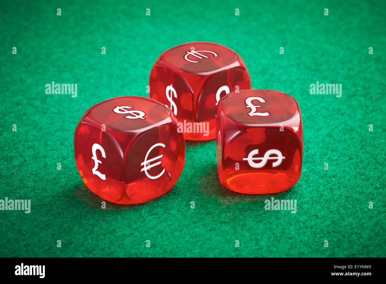 Currency exchange rate concept, three red dice on a green felt background. Stock Photo