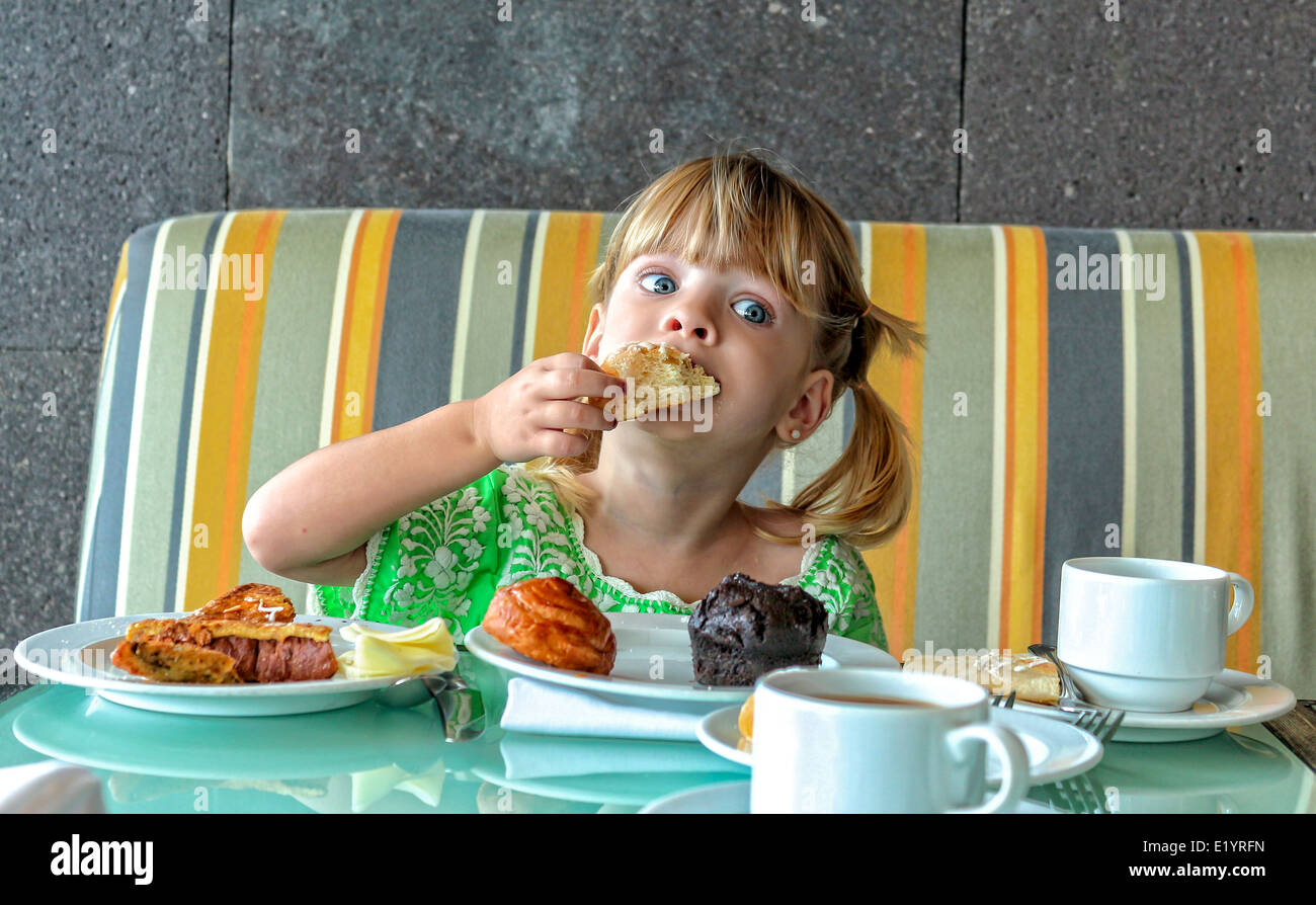 Cute little girl eating breakfast Stock Photo