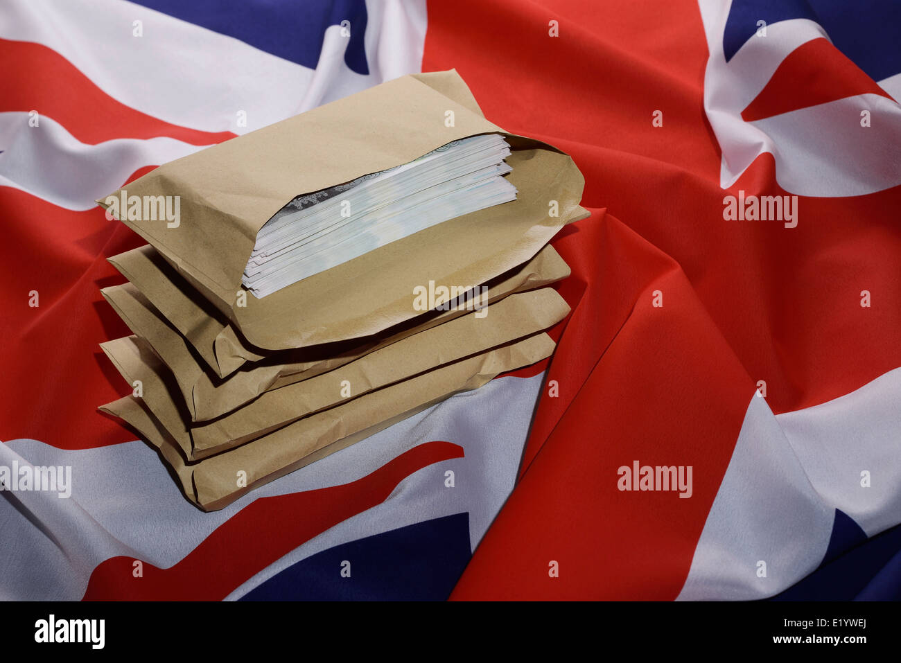Union Jack flag with brown envelopes full of money Stock Photo