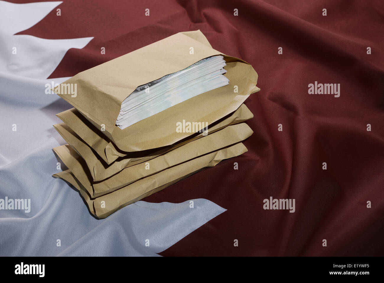 Qatar flag with brown envelopes full of money Stock Photo