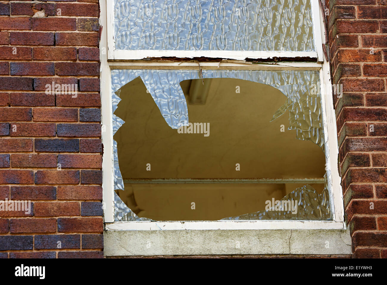 smashed broken window in an abandoned sixties office building England