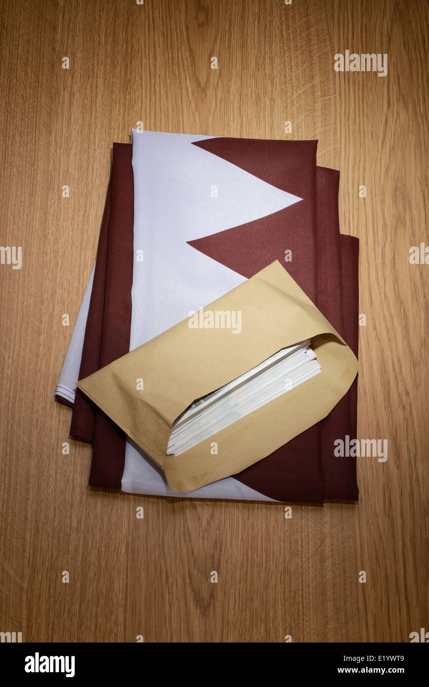 Qatar flag with a brown envelope full of money Stock Photo Alamy