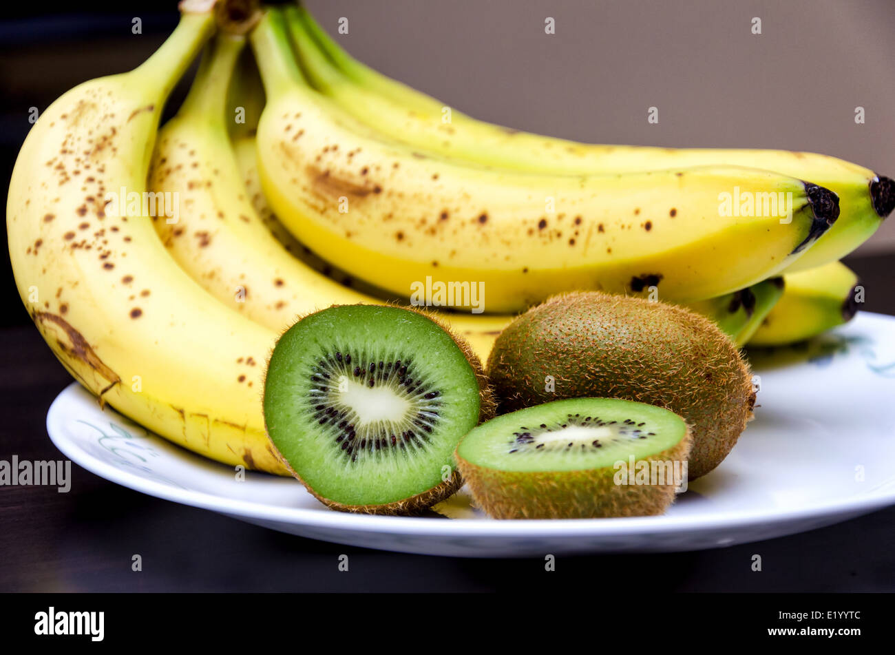 Kiwi and a bunch of bananas on a plate Stock Photo Alamy