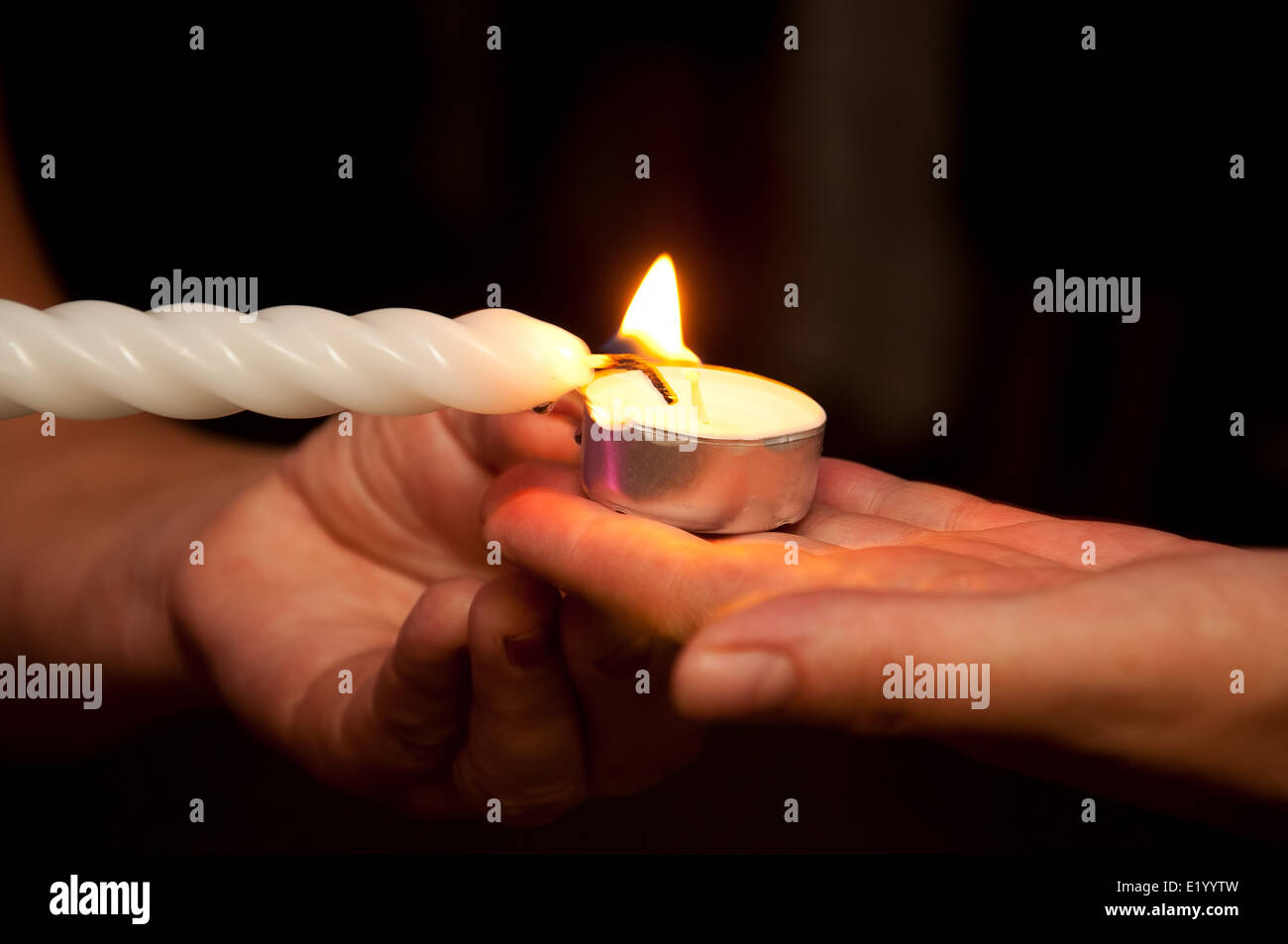 Hands lit candles Stock Photo