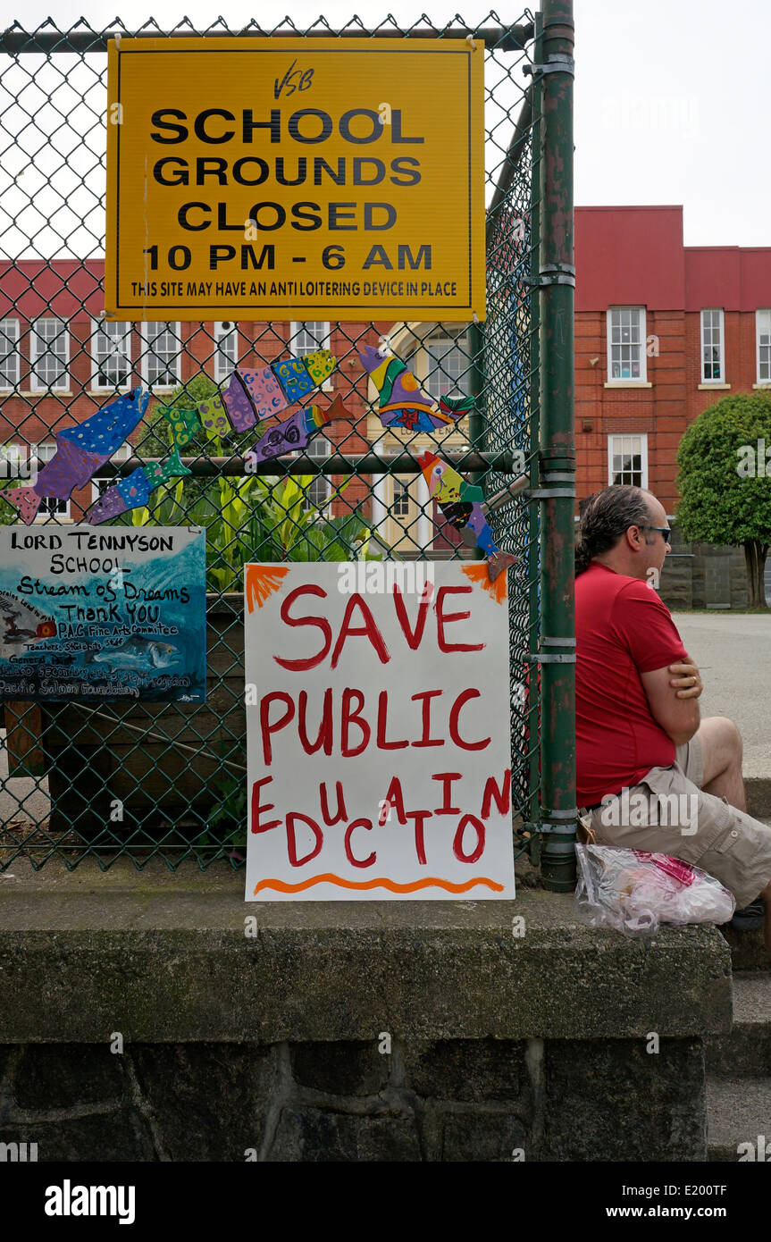 A striking British Columbia teacher sits next a protest sign outside A striking British Columbia teacher sits next a protest sign outside