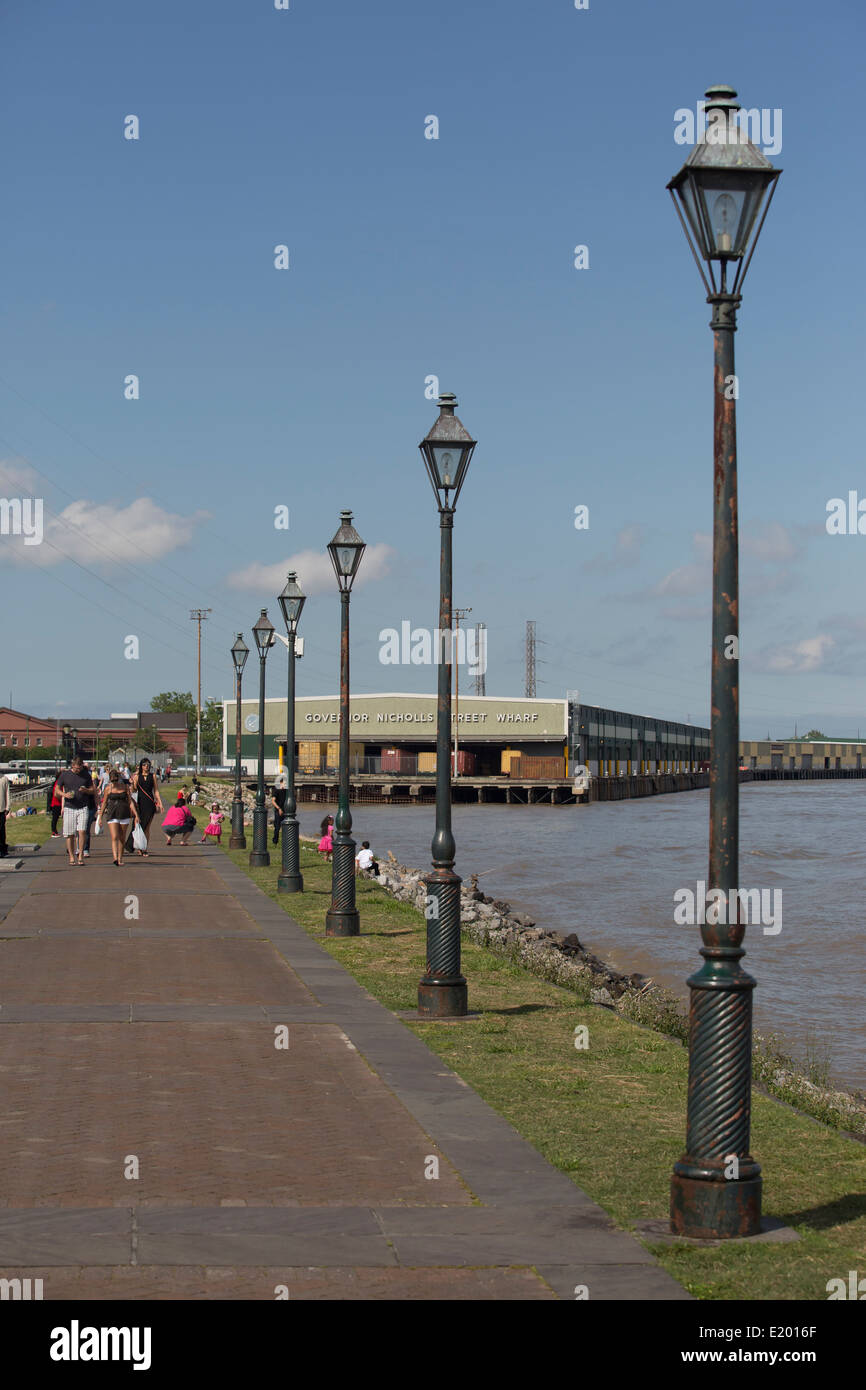 A path in New Orleans beside the Mississippi River is seen with a row of old fashioned street lights. Stock Photo